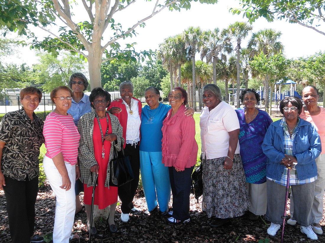 Photo by: Brittni Larson - The grandmothers pose after their meeting at the Rock Lake Community Center in Orlando on April 26. Yvonne Friend, far left, and Rounette Fulse, fifth from right, have both helped raise their children's children.