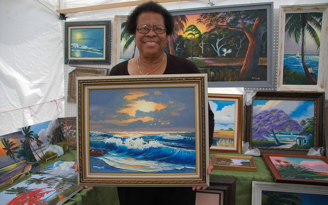 Photo by: Isaac Babcock - Original highwayman artist Mary A. Carroll shows off one of her paintings during the Hannibal Square Folk Art and Craft Festival on Saturday. The event featured works from local artists as well as eclectic music from the Porc...