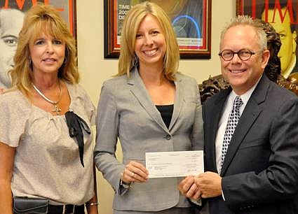 Cindy Reeves of Enterprise Holdings Group hands a check to Brent Trotter, president/CEO of Coalition for the Homeless of Central Florida.