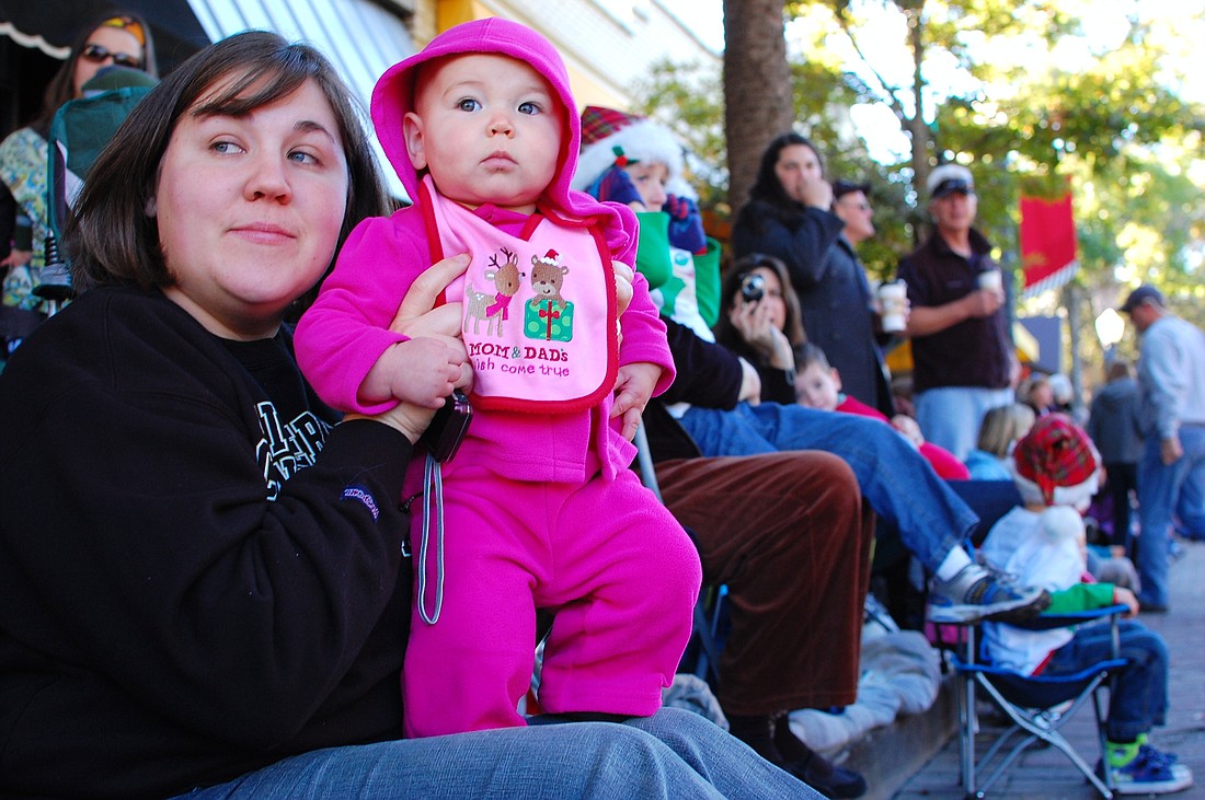 Photo by: Tina Russell - Nicole Knapp, 30 and Melanie, 8 months, wait for the 58th annual Winter Park Christmas Parade to start on Dec. 4.