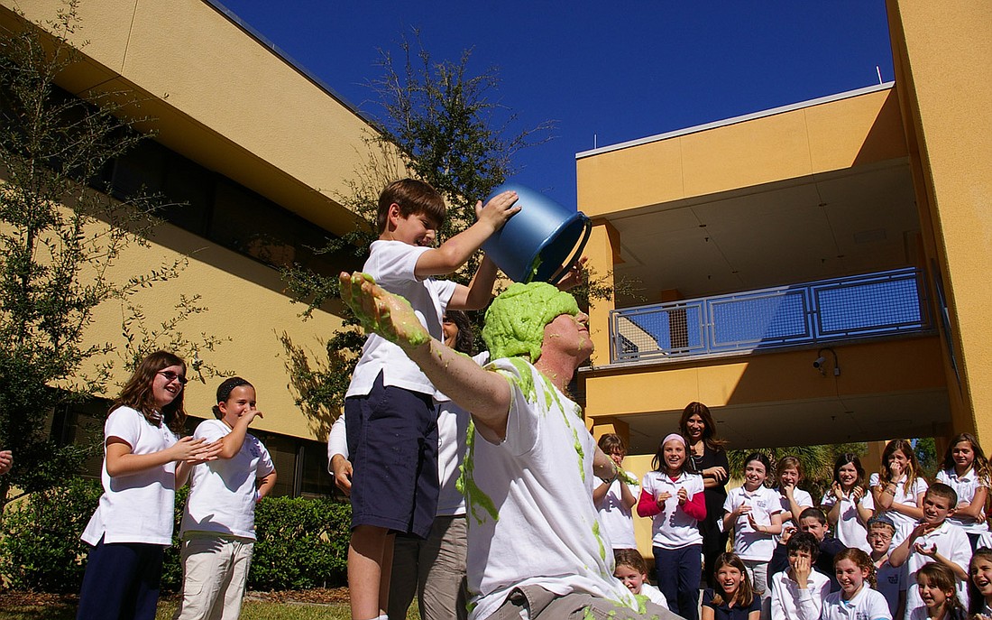 Photo by: Jenny Andreasson - Ben Perreault dumps a bucket of slime on a teacher. Jewish Academy of Orlando students slimed science teacher and athletics coach Sean Bowmer for surpassing their goal of money raised for Jump Rope for Heart. The slime was...