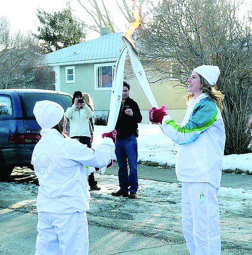 Photo by: Brittni Larson - UCF freshman Kaitlyn Chana lights her torch for her run through Calgary on Jan. 19. Chana was chosen as a torchbearer for the 2010 Winter Games because of her charity, Love Letters: Random Cards of Kindness.