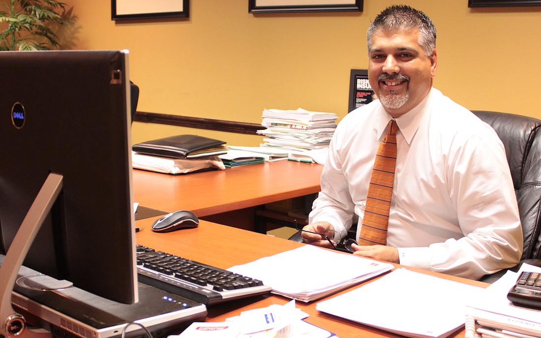 Photo by: Amanda Georgi - Ivan Valdes sits at his desk on April 13 at his Maitland financial firm. He'll be sworn in to the Maitland City Council on Monday, April 25.