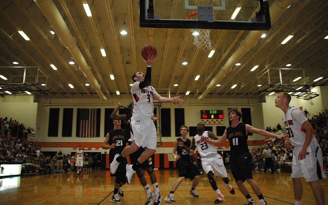 Photo by: Isaac Babcock - Winter Park's Brett Comer flies toward the basket in the Wildcats' win over DeLand. Comer put on a show in the game, stealing the ball six times and picking up 14 points to bamboozle the Bulldogs. Austin Rivers led the team w...