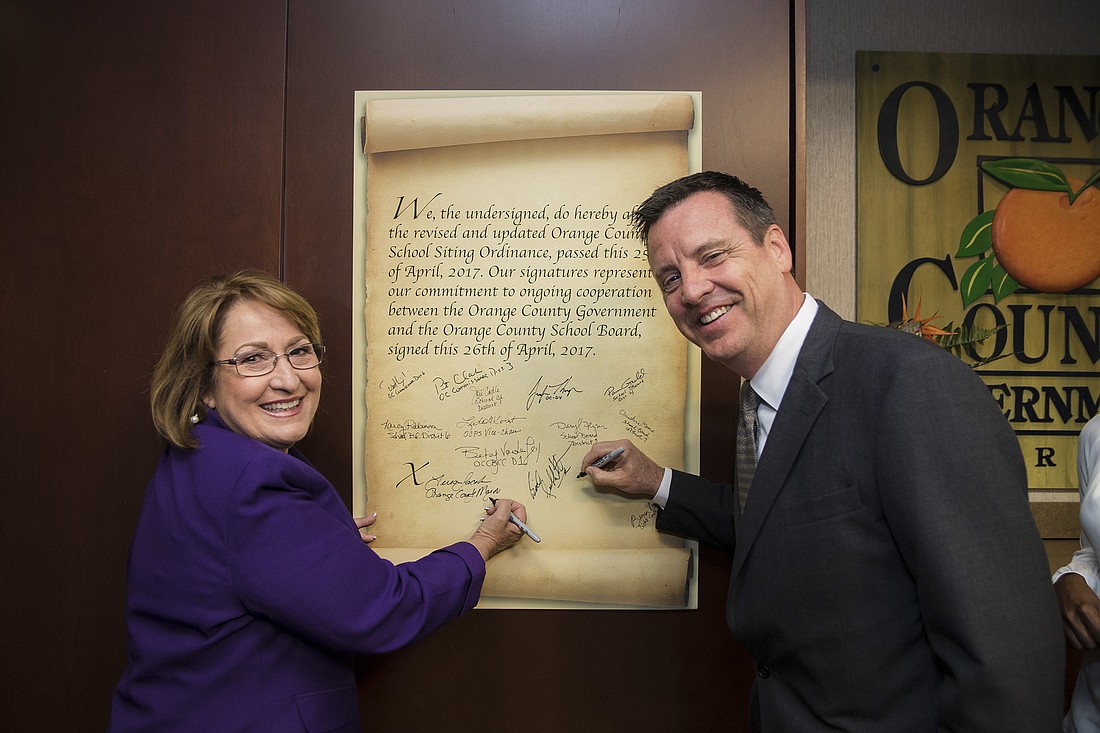 Orange County Mayor Teresa Jacobs and Orange County School Board Chairman Bill Sublette participate in a ceremonial signing of the updated school siting ordinance.
