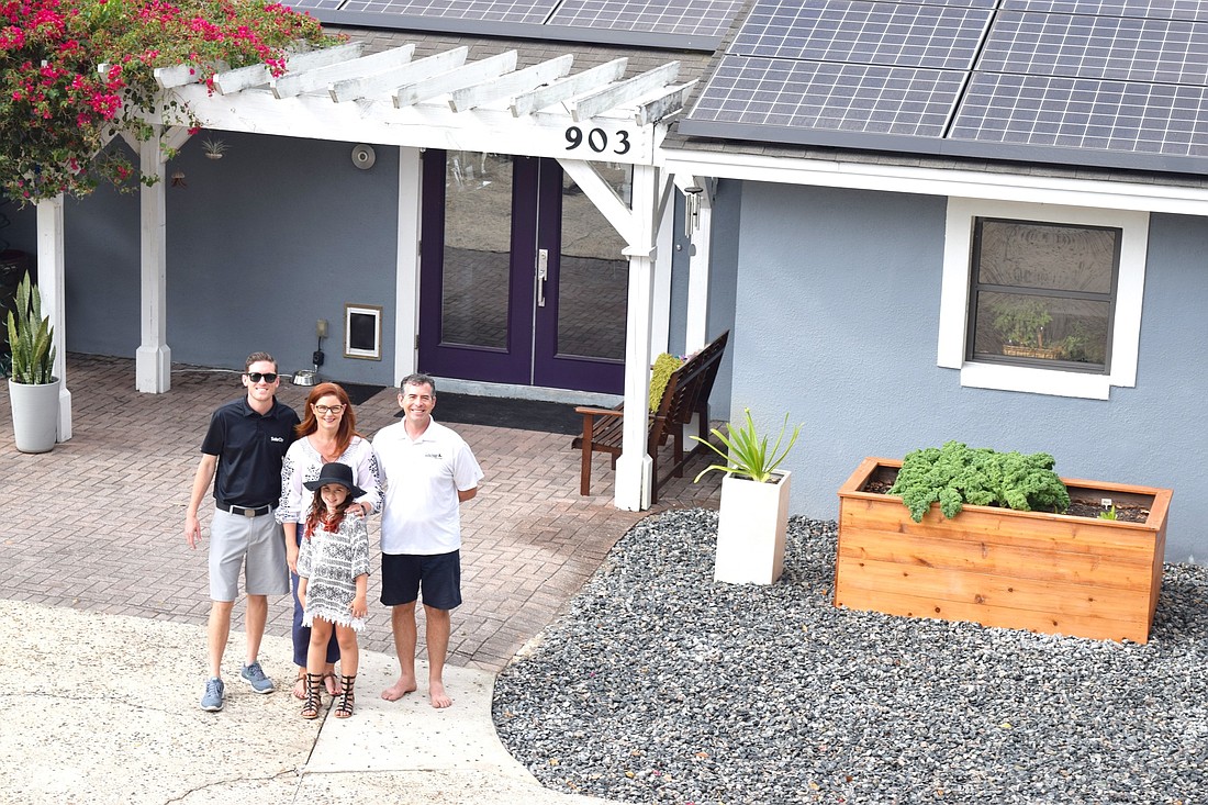 The Williams family shows off its new solar panels with SolarCity representative Scott Smith. From left: Smith, Colleen Williams, Loren Williams and Andy Williams.