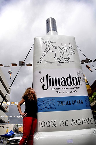 Cocina 214 co-owner Lambrine Macejewski admires a giant inflatable el Jimador Tequila bottle on Welbourne Avenue as crews put together decorations for Cocina 214&#39;   s annual Cinco de Mayo party Friday.
