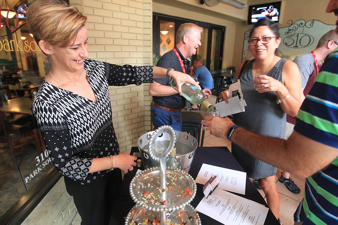 Brook Hayden, left, prepares a glass of wine for customer outside of 310 Park South in downtown Winter Park during Sip, Shop, & Stroll late Thursday afternoon.