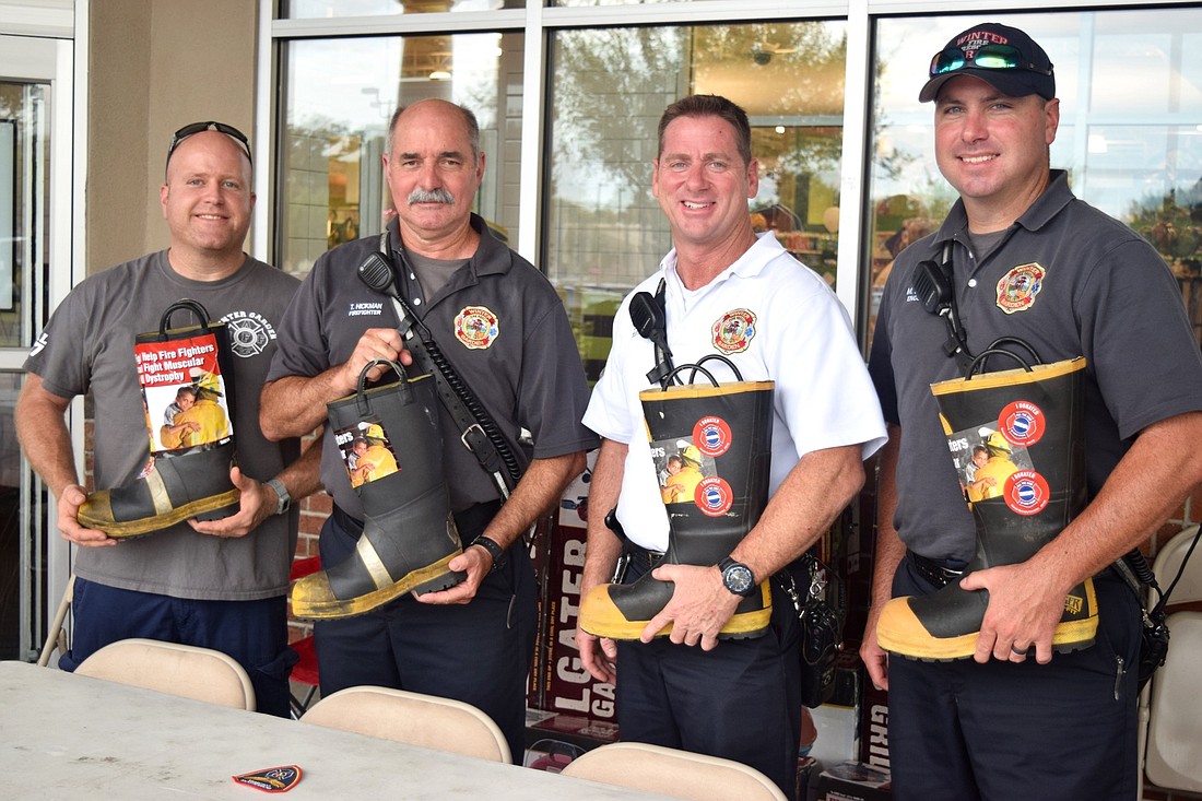 Fire engineer Tim Dunmire, left, firefighter Tim Hickman, Lt. Sean Riser and fire engineer Mike Gurney helped collect funds for the Muscular Dystrophy Association Friday, Aug. 25.