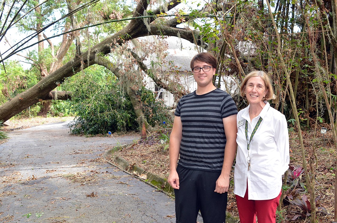 David Chomanics, resident caretaker, and Angela Withers, board president, are happy the giant laurel oak on the north side of the property merely grazed the corner of the cottage.
