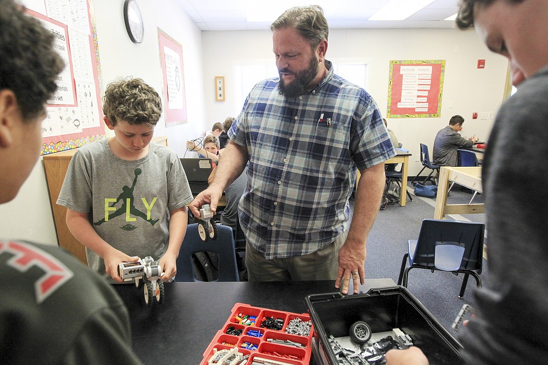Giles, right, helps out student Liam Jones with his robotics project.