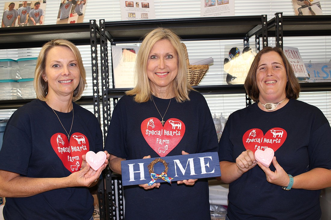 From left to right, Jennifer Elliott, Kathy Meena and Emily Rouse are in charge of the Special Hearts Farm at Dr. Phillips High School. Students who work at the Special Hearts Farm create goats-milk soap and rustic signs.