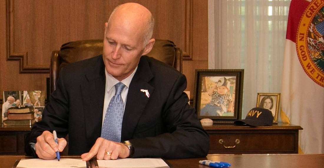 Florida Gov. Rick Scott signs HB 487, which will allow child survivors of sex trafficking to receive specialized care at hospitals and residential treatment centers. (Courtesy of Florida Representative Bobby Olszewski)