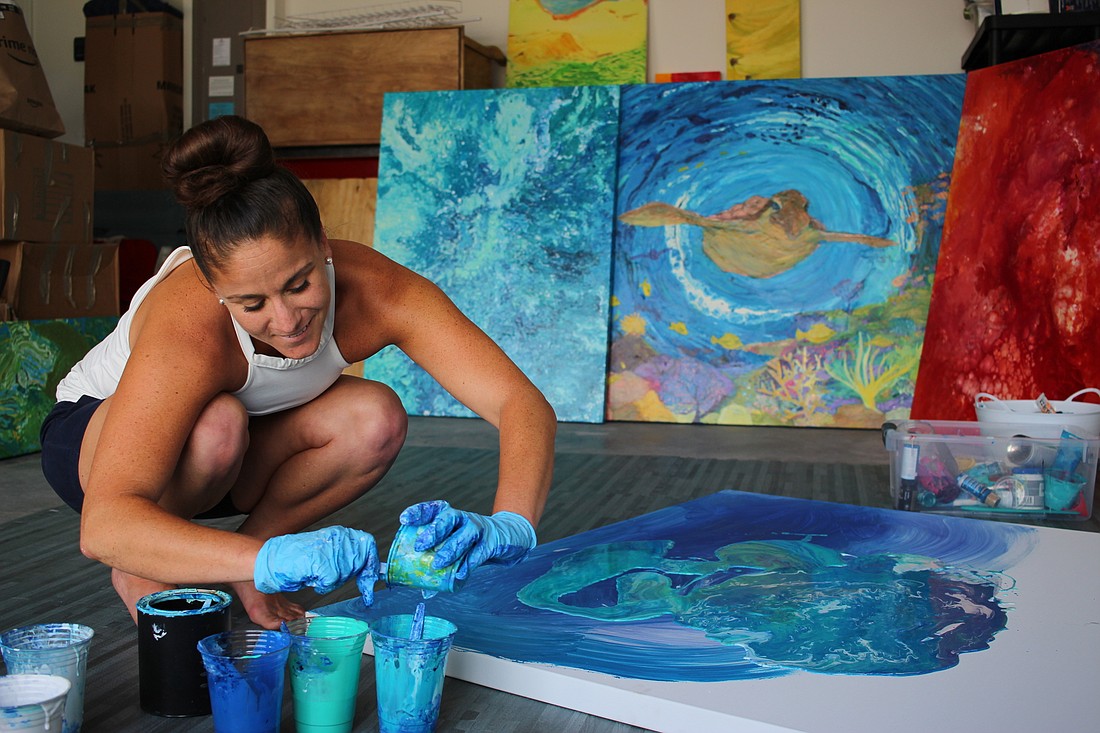Jennifer Parris blends several different colors to create her fluid-art painting.