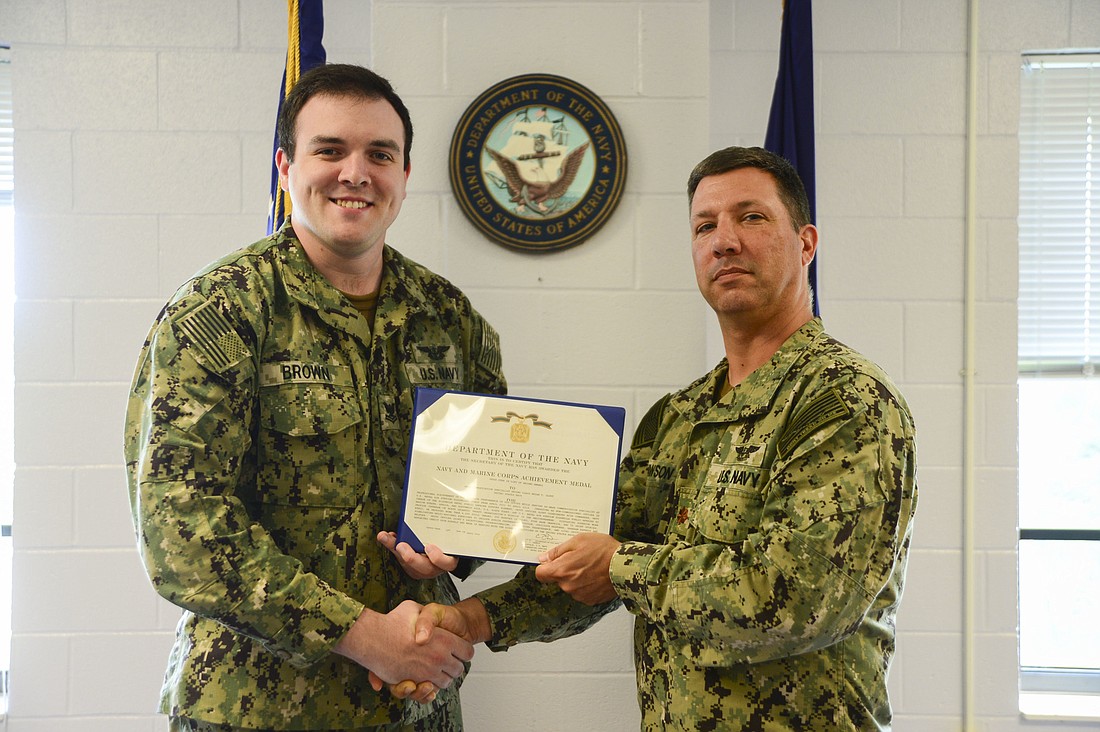 Petty Officer Second Class Jackson Brown, left, received the Navy and Marine Corps Achievement Medal from Lt. Commander Brett Dawson.