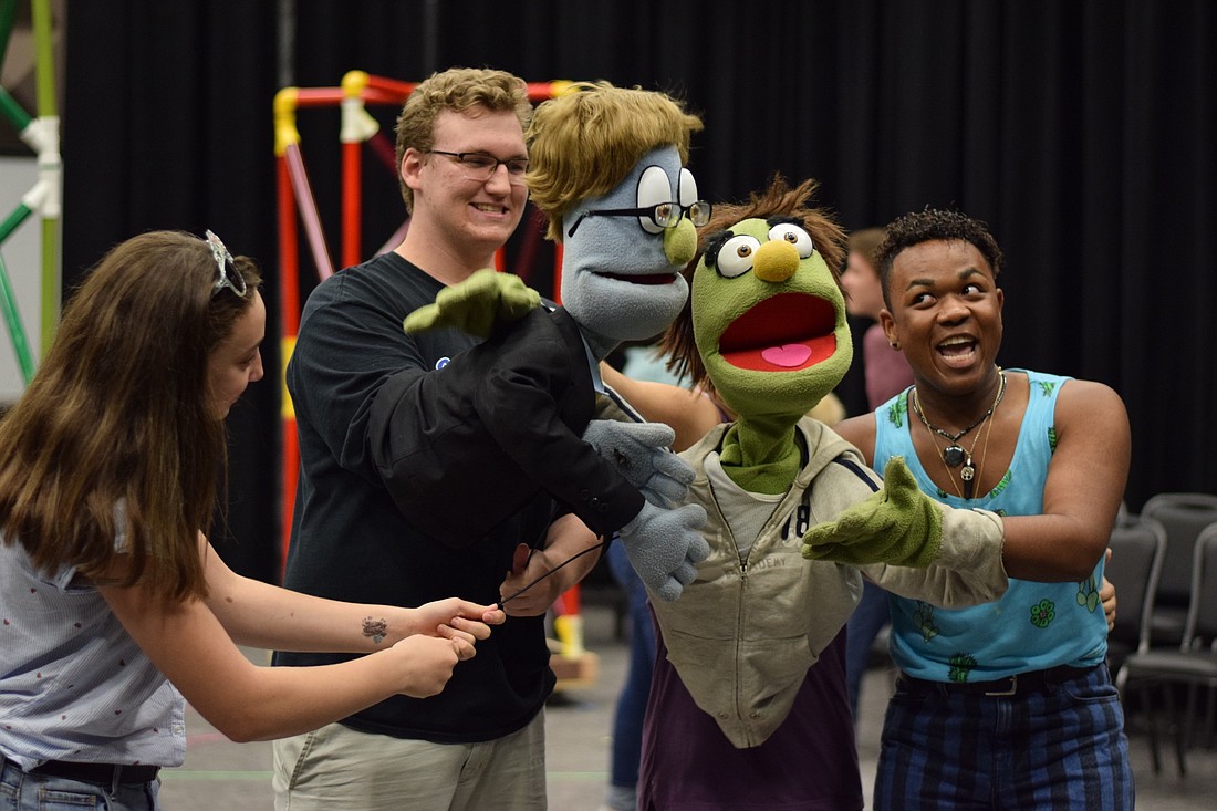Students practice with their puppets during a rehearsal of â€œAvenue Qâ€ at the school on Monday, July 9.