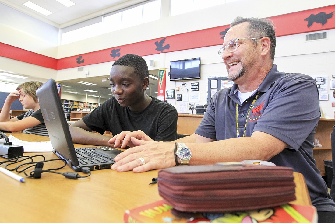 Photo by Troy Herring: Maitland Middle Staff Specialist David Bloom, right, helped student Omarion Fenn with his new county-issued laptop.