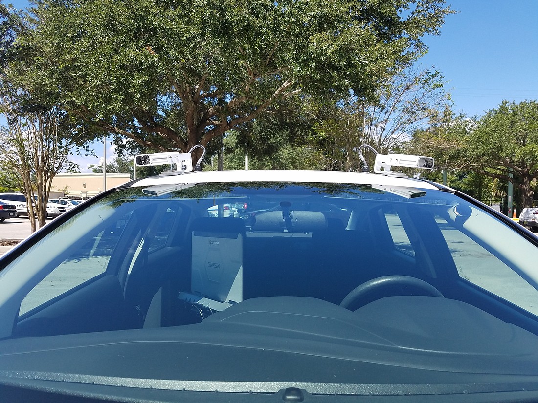 The new technology for parking enforcement sits atop the enforcement officerâ€™s car.