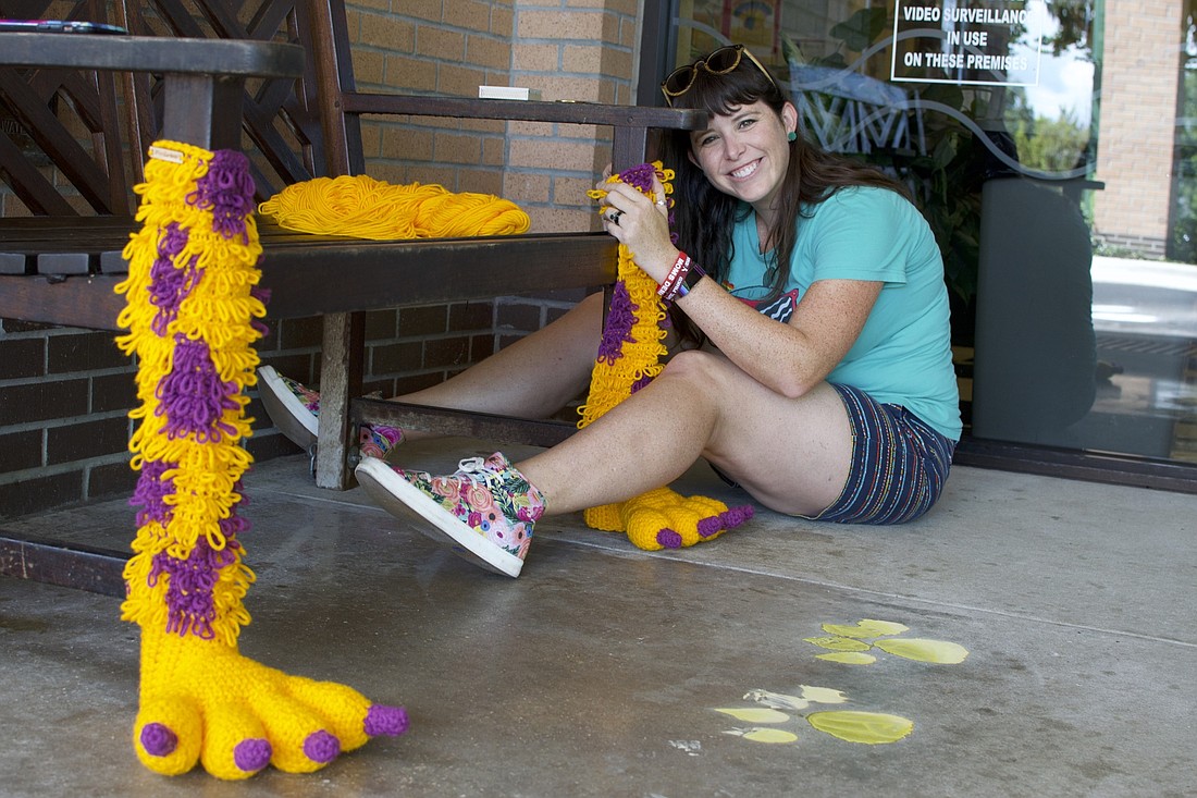 Winter Garden resident Jennifer Parrish attaches monster feet to the legs of a bench located at the West Oaks Branch Library in Ocoee.