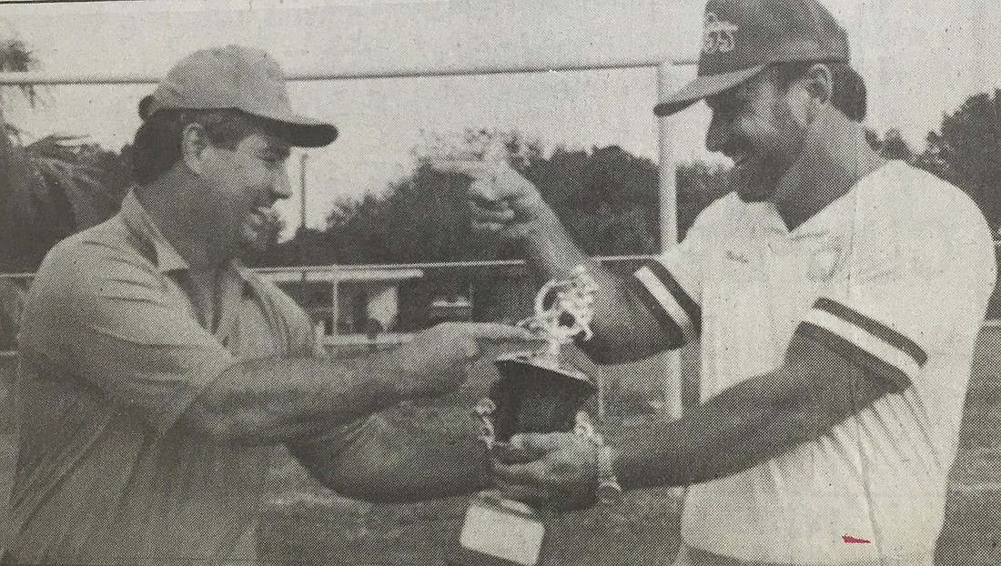Russell Crouch, left, president of the Winter Garden Youth Football League (the Wildcats), and Bob Clark, president of the Ocoee Junior-Senior Football League (the Bulldogs), play tug-oâ€™-war with the trophy that was awarded at the first Dog and Cat Bowl.