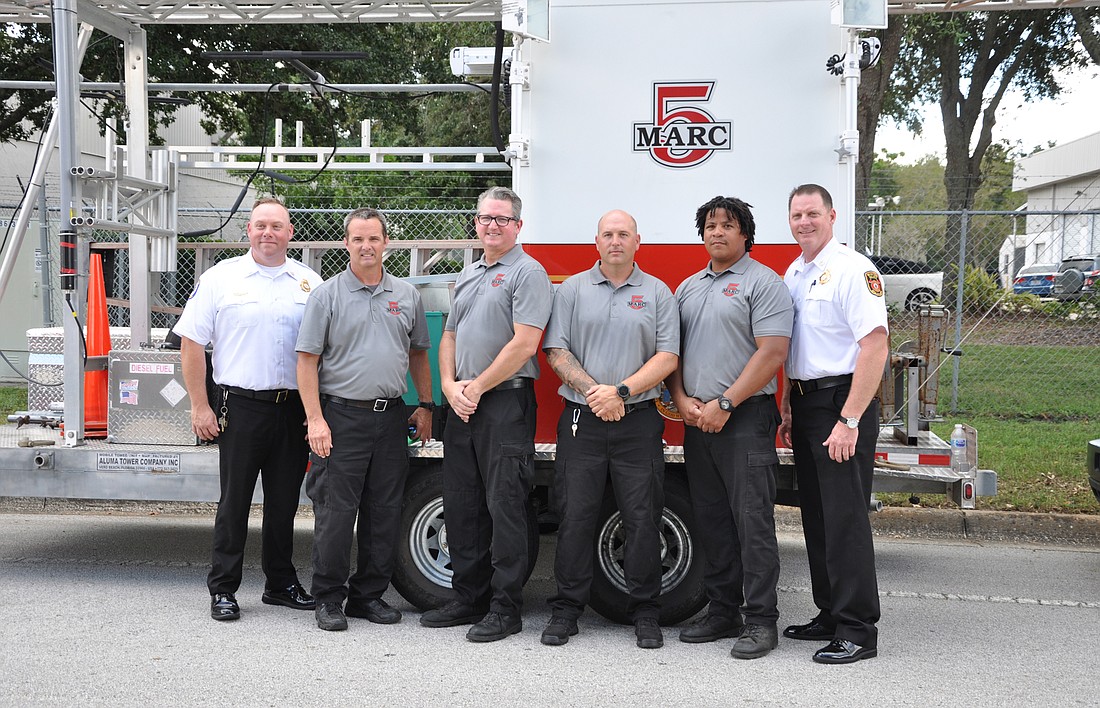 Deputy Chief Ryan Fischer, Rodney Childers, Andrew Isaacs, Bryan Moman, Alfredo Escalera Jr. and Fire Chief Dan Hagedorn stopped for a photo with the MARC communication tower.