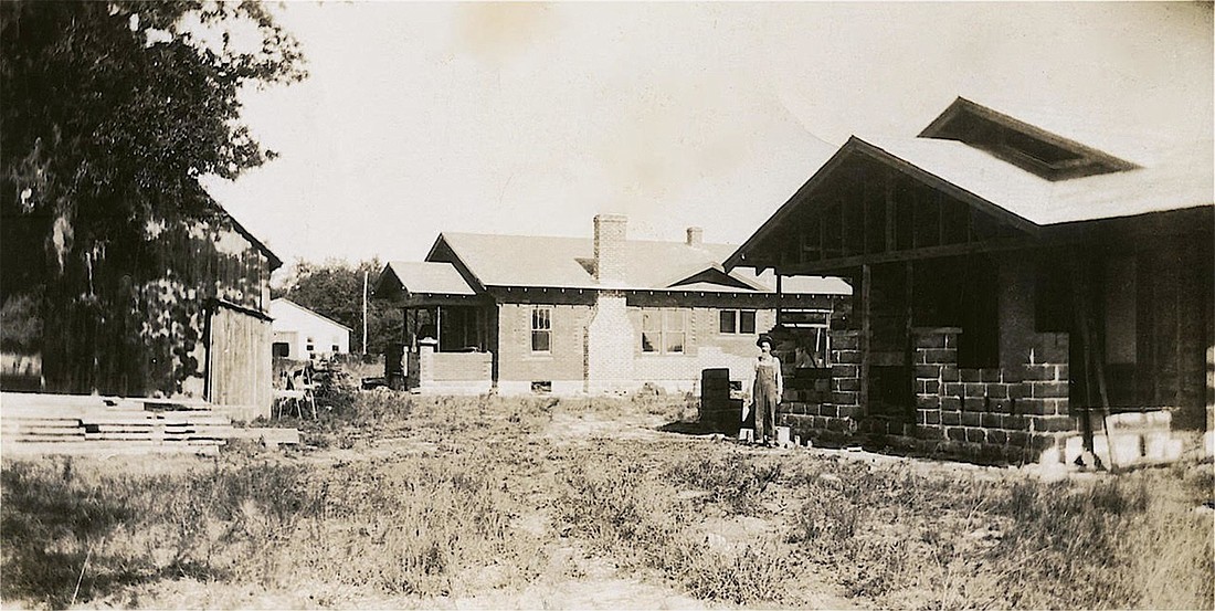  Henry A. Wilkening stands with two of the three homes he built for his daughters. This photo was taken in 1925, when he built the two homes. The home to his right is near completion.