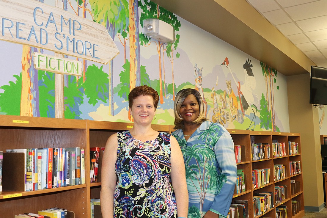 Media Specialst Isabel Turner, left, and Media Clerk Christine Wallace are ready to welcome students to Camp Read Sâ€™more at the Ocoee Elementary library.