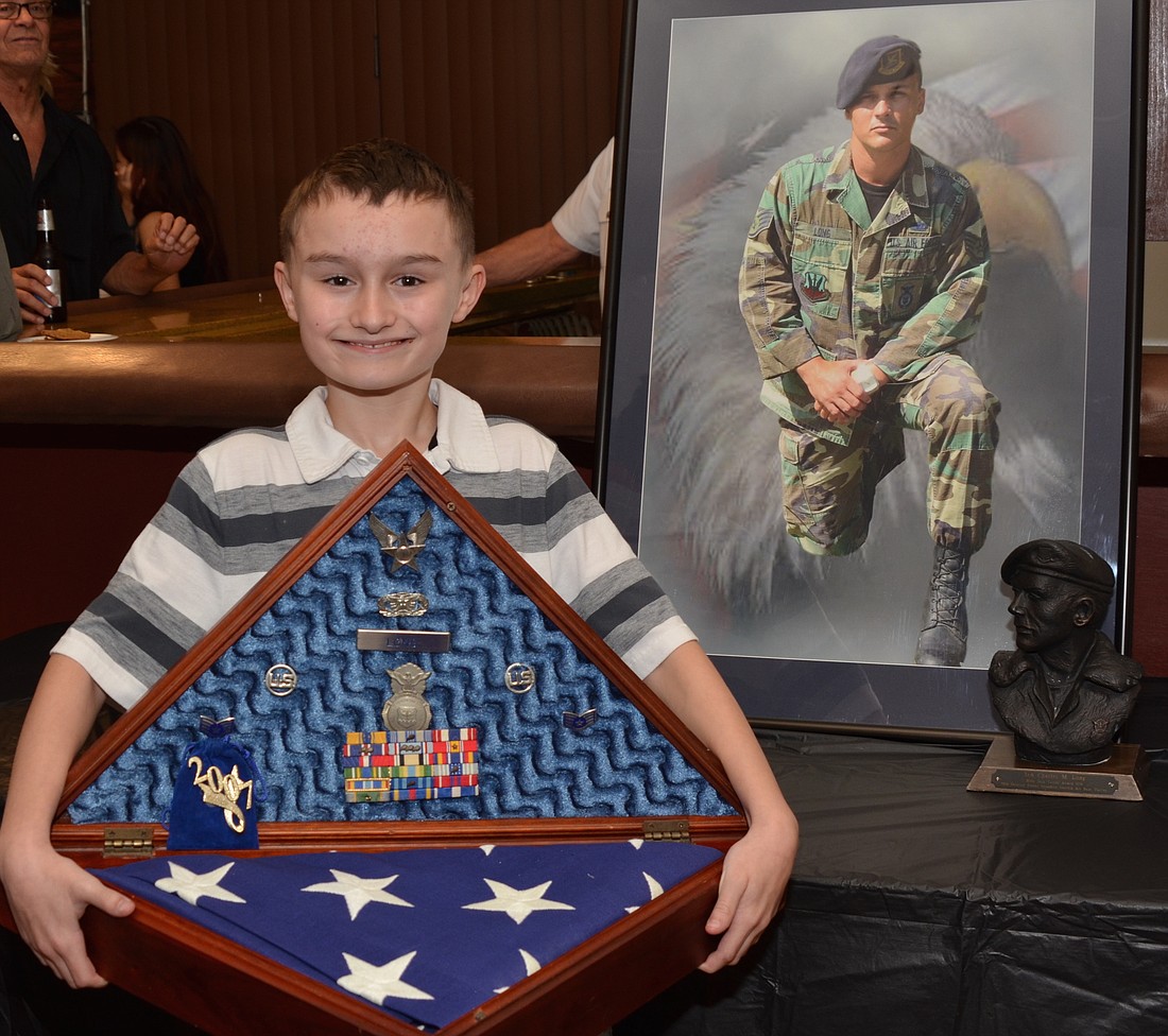 Trip Long holds his late fatherâ€™s shadow box that was returned to the family last week. It has the flag that draped Mike Longâ€™s coffin, his military service ribbons, police badge and bullet casings from the funeral&#39;s 21-gun salute