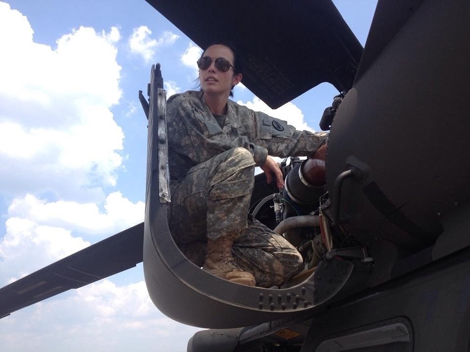 Rachel Chiles sits in an Army Blackhawk helicopterâ€™s open engine cowling for the No. 1 engine, situated above the left-hand cargo door.