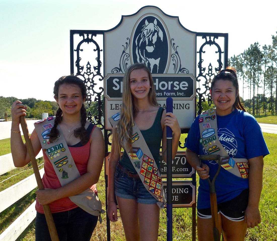 Girl Scouts Karlen Randle, left, Amber Wilkinson, center, and Taylor Smith, right, spent a Sunday morning planting bushes along the fence line at SpiritHorse at Better Times Farm in Winter Garden.
