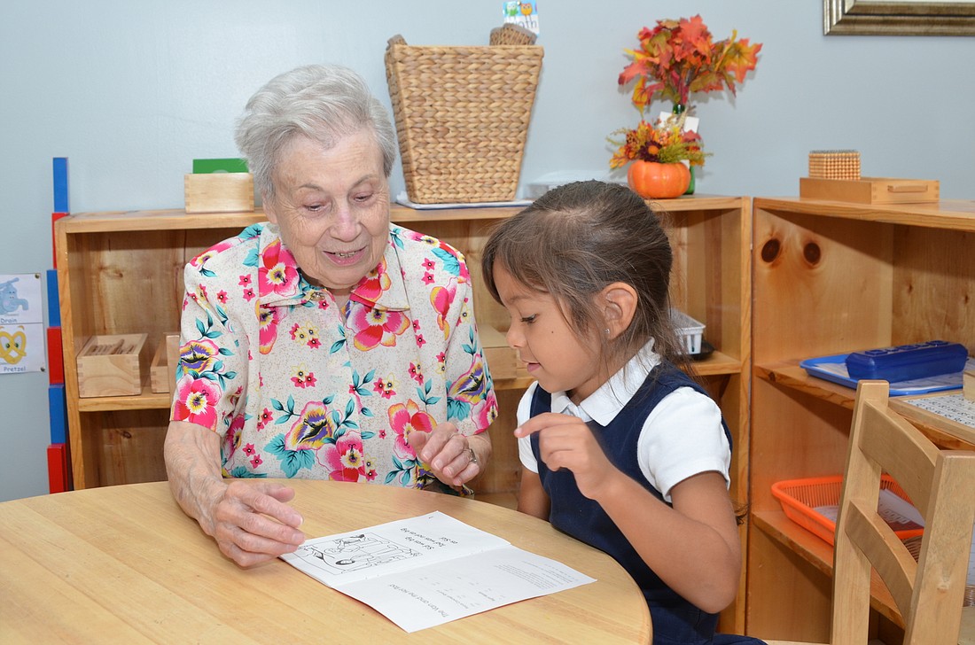 Frances Kaufman helps Kayliana Leguizamon sound out words in her reading booklet.