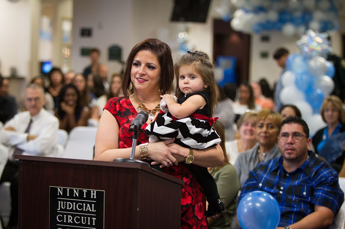 Diana Bonilla, of Winter Garden, holds her 21-month-old daughter, Madison, during the Nov. 18 adoption ceremony at the Orange County Courthouse.