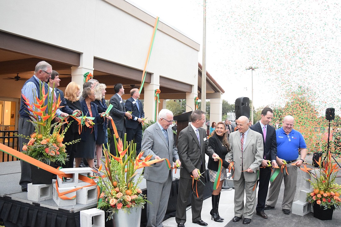 YMCA board members and community donors all helped cut the ribbon as green and orange confetti filled the air.