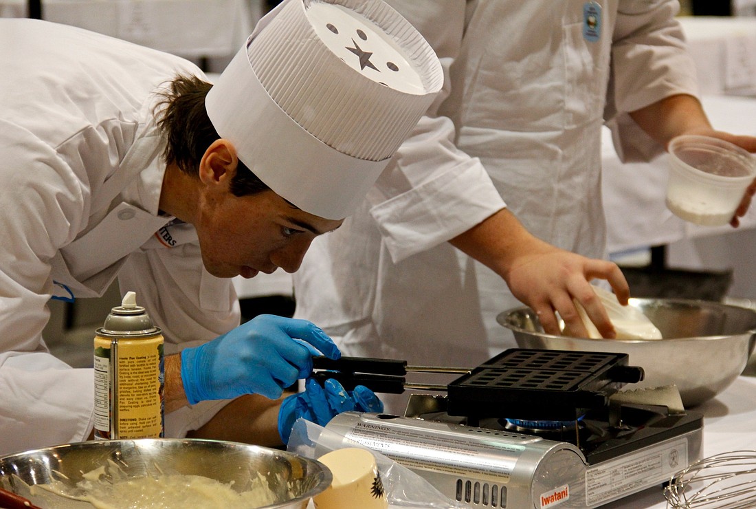 Tabor Filipello, a senior at Ocoee High School, monitors his waffle iron while cooking a dessert during the Orange County Culinary and Hospitality Competition.