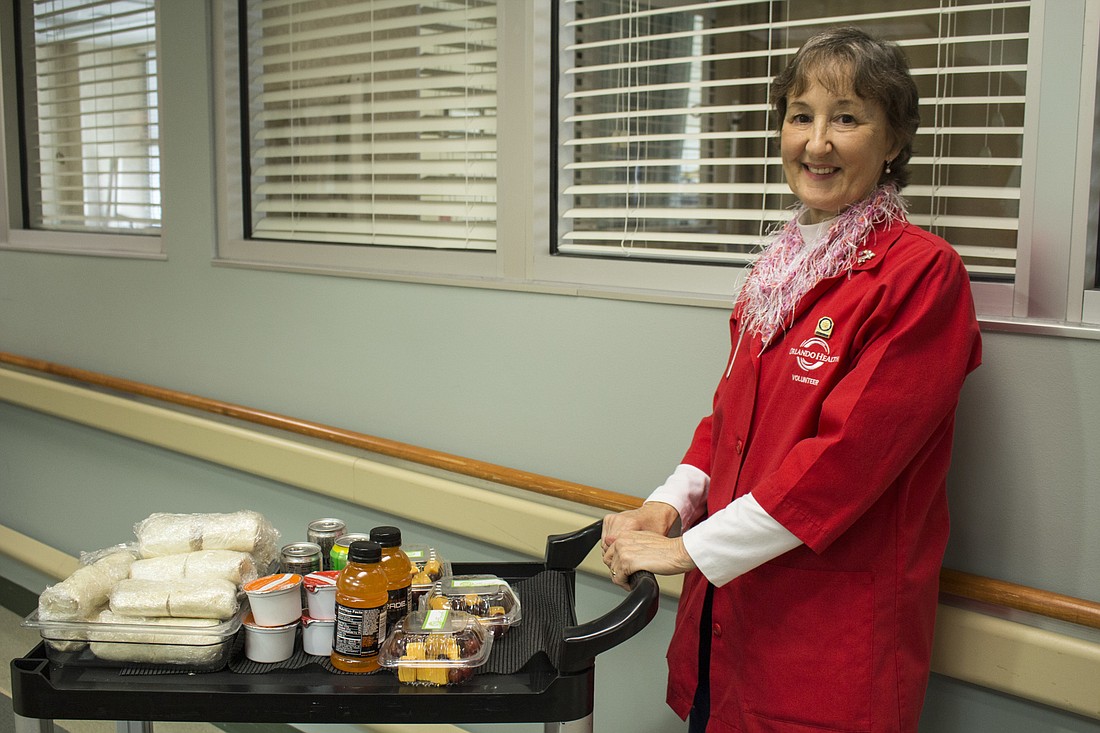Jane Guida at the UF Health Cancer Center with a food cart filled with snacks she distributes to patients receiving treatment.