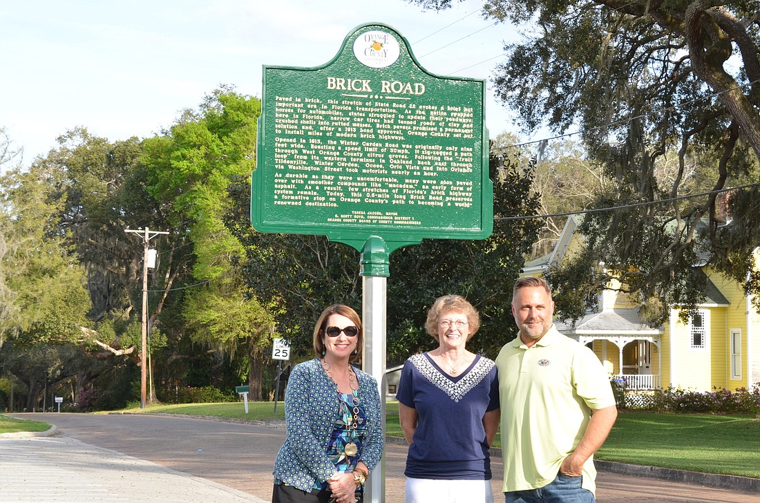 Orange County District 1 Commissioner Betsy VanderLey, left, and former commissioner Scott Boyd unveiled the historic marker for Brick Road in Tildenville. Glenda Loew, center, has fought for years for the preservation.