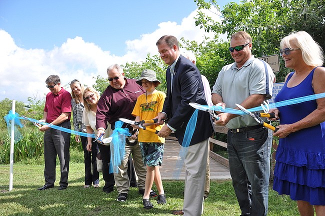 Photo by: Tim Freed - Members of the Winter Park City Commission, city staff and wetland volunteers cut the ribbon for a new boardwalk on June 16.