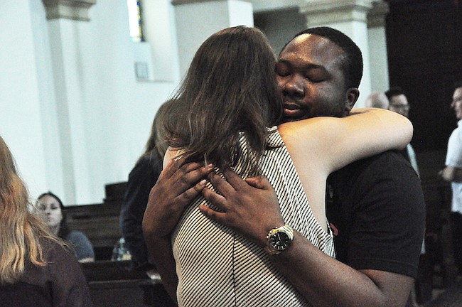 Photo by: Tim Freed - Rollins College senior Rayshaun Wagner recieves a hug at a vigil on campus Monday. He lost three friends in the Pulse shooting.
