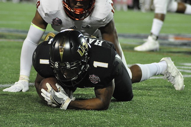 Photo by: Tim Freed - The Knights' Jawon Hamilton lays on the ground after a hit from the Arkansas State defense. The team amassed 12 rushing yards.