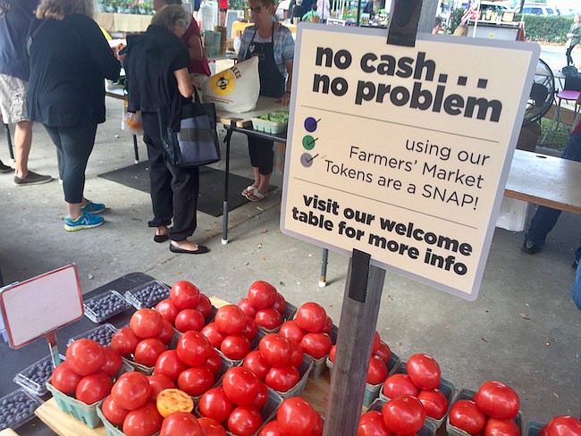 Photo by: Jarleene Almenas - Signs advertise expanded ways to pay at the Winter Park Farmers Market, which began accepting SNAP/EBT cards Feb. 4, combining with matching Fresh Access Bucks to make food more affordable.