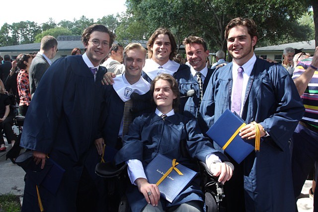 Photo courtesy of Night family - Three classmates helped hold John Michael Night, center, as he was shuffled toward Trinity Prep Principal Dennis Herron to receive his diploma at graduation, showing the most outward signs of improvement since tragedy ...