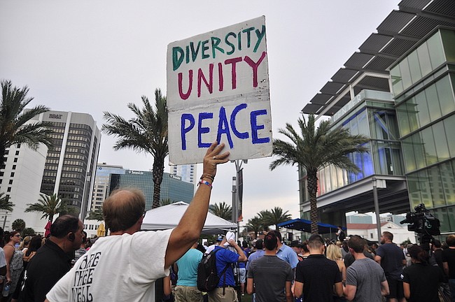 Photo by: Isaac Babcock - Thousands of residents gathered outside the Dr. Phillips Center for the Performing Arts in mourning on Monday following a brutal shooting at the Pulse Orlando nightclub on Sunday morning that killed 49 people and put 53 more ...