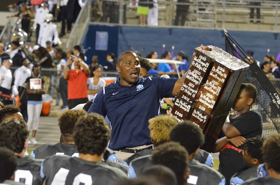 Dr. Phillips coach Rodney Wells holds up the Ol' Orange Crate rivalry trophy after the Panthers' 40-3 victory against West Orange returned it to their possession.