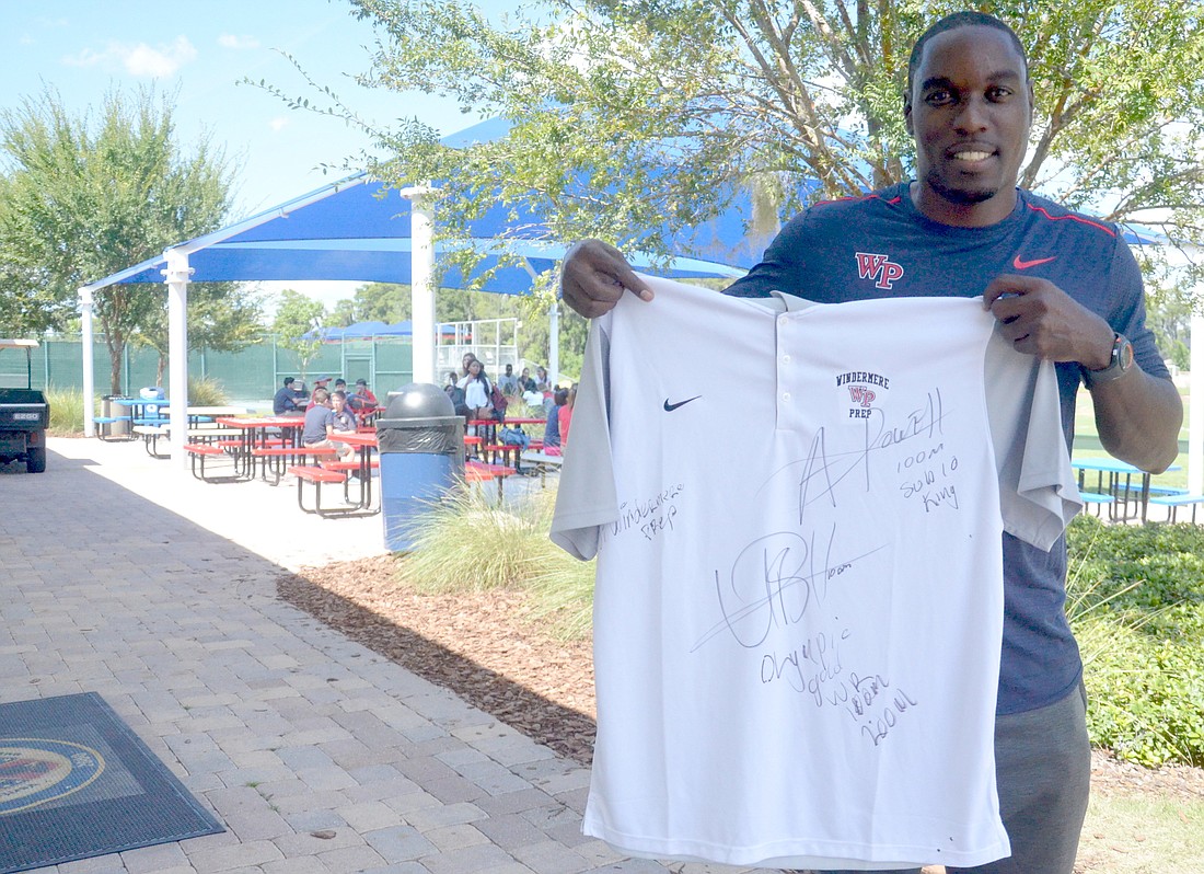 Windermere Prep track and field coach Dwight Thomas, a former Olympian, shows off a shirt signed by Usain Bolt and Asafa Powell.