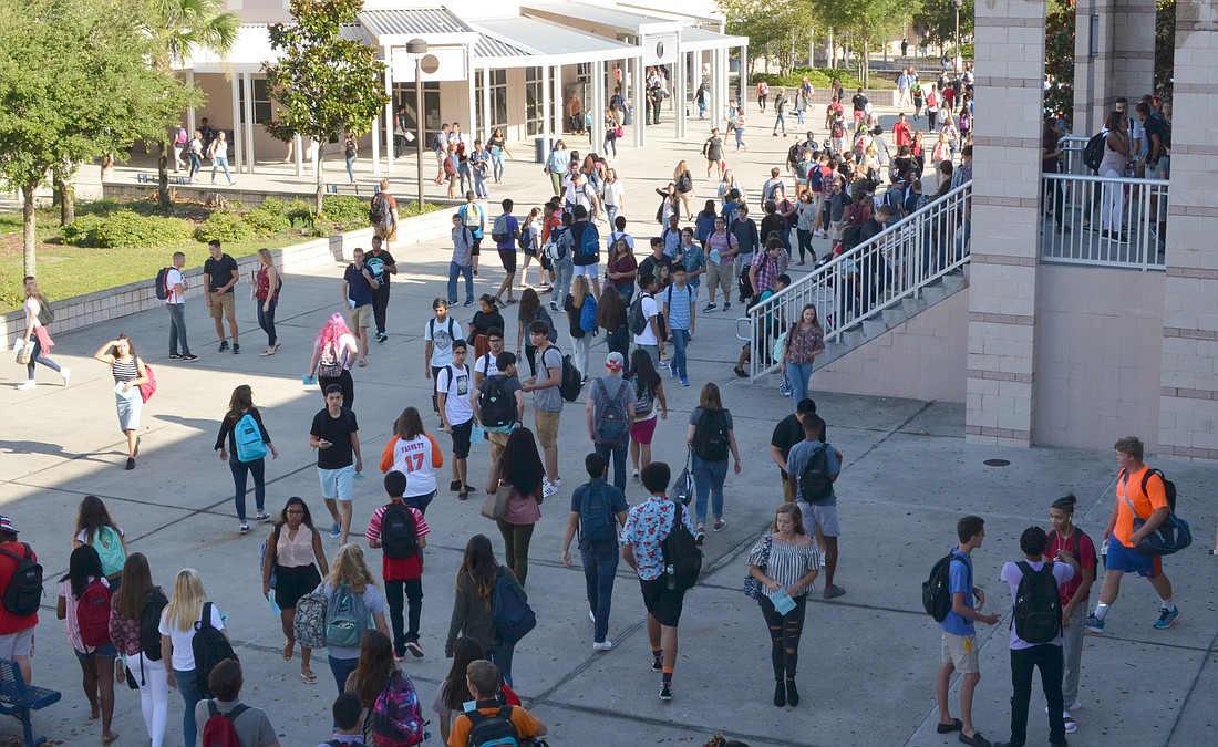 Some of the roughly 4,300 students make their way through the crowded courtyard to beat the tardy bell on Monday, the first day of classes for Orange County Public Schools.