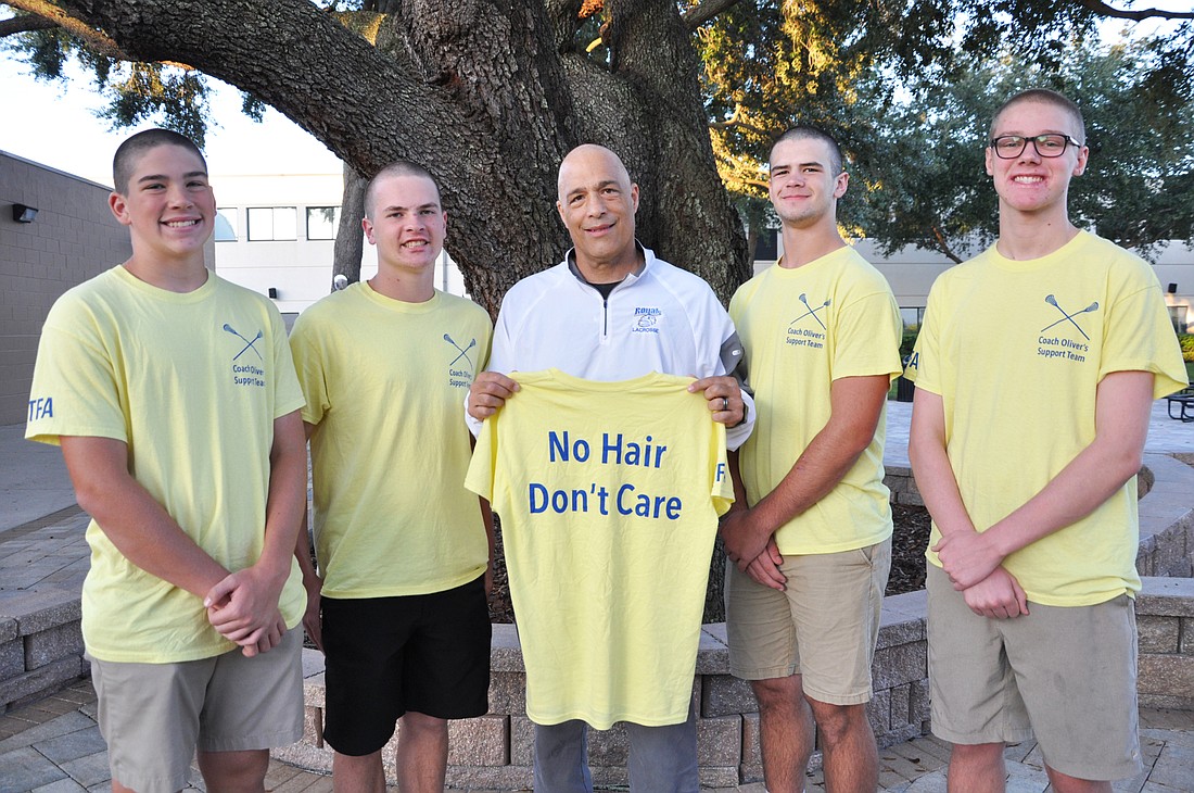 The First Academy lacrosse players Noah Nixon, Joshua Harvey, Jacob Forbes and Grant Pifer all shaved their heads as a sign of support for coach David Oliver, center, as he fights cancer.