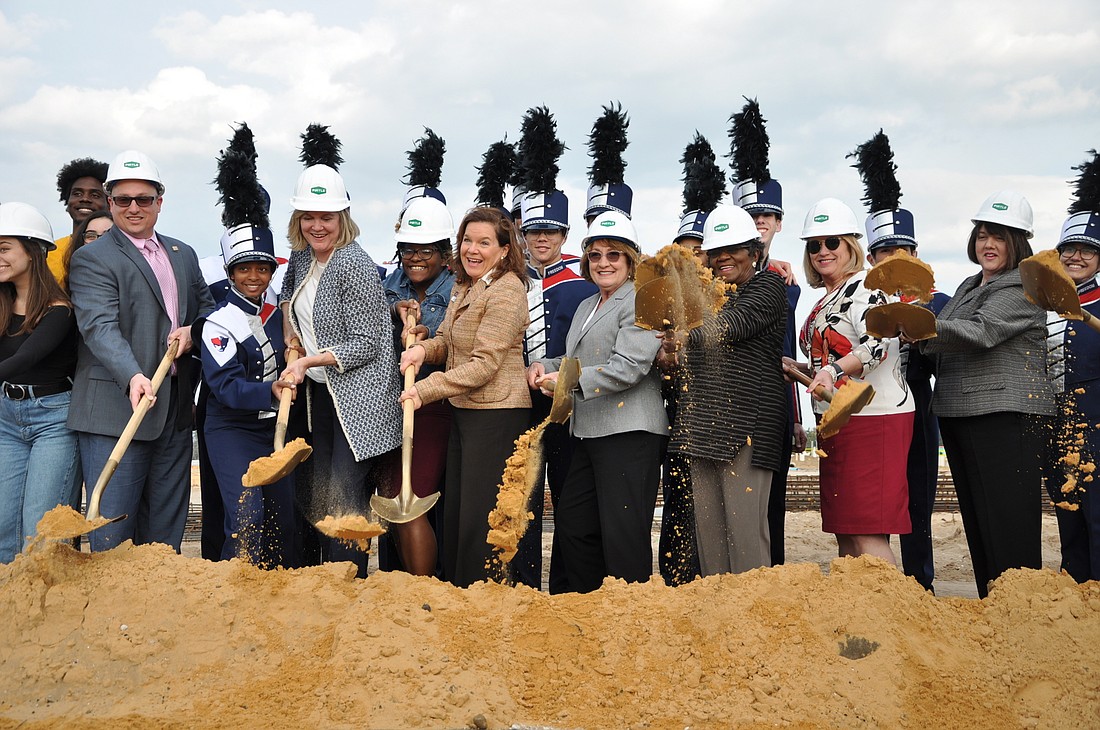 Local leaders and students from Dr. Phillips and Freedom high schools dug their shovels into the dirt to celebrate the construction of the new school.