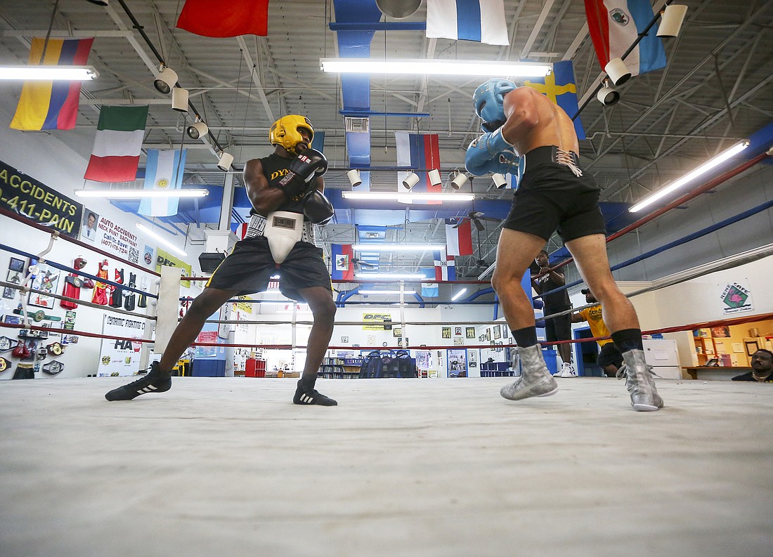 Derrick Jackson, left, takes in a sparring session with professional boxer Christopher Diaz at Reneâ€™s Dynamic Sports Center.