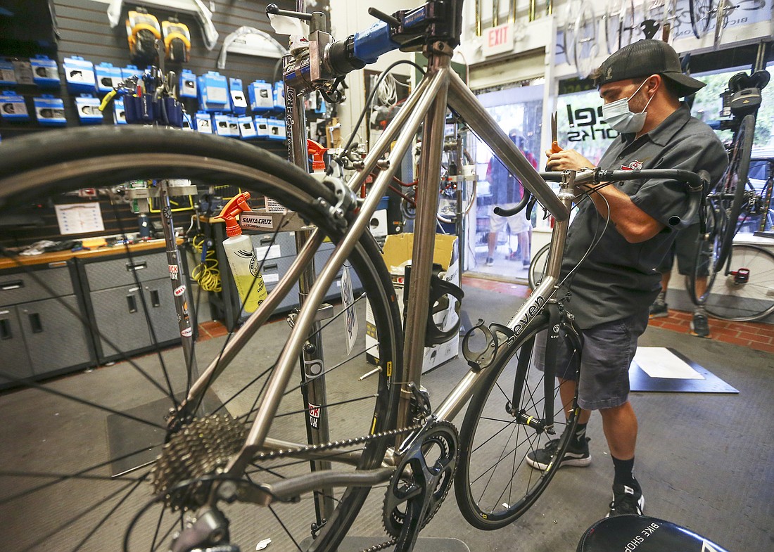 Tyler Junkins works on a bikeâ€™s handlebars in the shop at Winter Garden Wheel Works