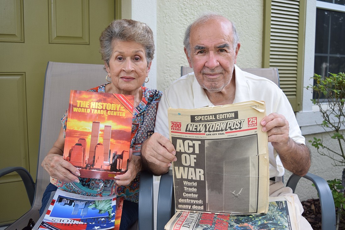 Horizon West residents Elsa and Hector De Jesus hold up newspapers from the Sept. 11, 2001, attacks.